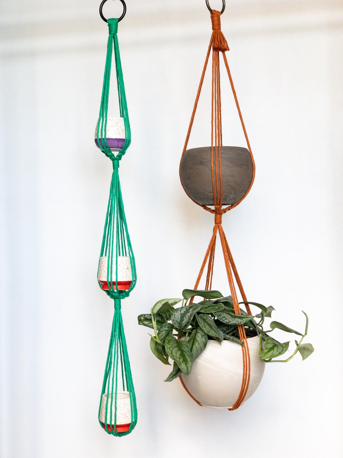Two plant hangers. One holds 3 pots the other holds 2 pots. Shown in Kelly Green and Copper